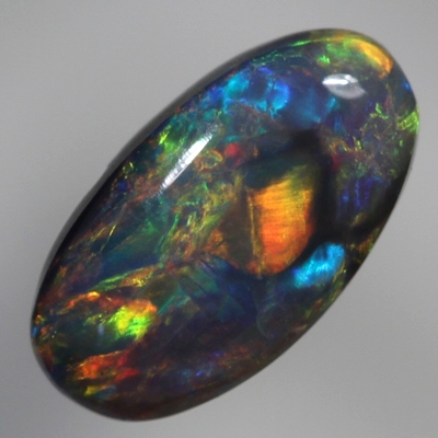 SOLID BLACK OPAL Cherry red and orange over a green/blue background